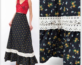 Könnte beinhalten: Ein zweiteiliges Vintage-Outfit mit einem roten Oberteil mit Paisley-Muster und einem langen schwarzen Rock. Der Rock hat ein Blumenmuster mit gelben und blauen Blumen und weißen Spitzenbesatz. Das Outfit ist im Retro-Stil.