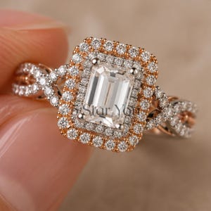 May include: An emerald-cut center stone ring featuring a double halo of small round diamonds set in rose gold. The band has a twisted design encrusted with pavé diamonds. The text Star You is visible on the center stone of the ring.