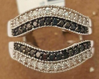 May include: A silver ring with a curved design featuring two rows of black and white diamonds.