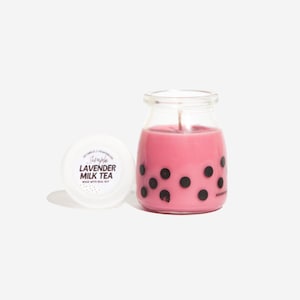 Op de afbeelding: Een roze glazen potkaars met een zwart-wit boba-theeontwerp. Het deksel is wit met de tekst "Simple Lavender Milk Tea Made with Real Soy".