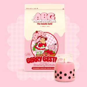 May include: A pink and white candle jar with a black and white boba tea design. The candle is labelled "Berry Best" and "The World of Strawberry Shortcake". The jar is sitting on a white and pink background with a cartoon image of Strawberry Shortcake.