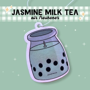 May include: A white car air freshener shaped like a glass jar of jasmine milk tea with black boba pearls. The text "Jasmine Milk Tea air freshener" is printed on the top of the air freshener.