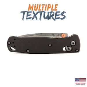 May include: A black folding knife with a textured handle and a silver blade. The knife has a small orange accent and the text "MULTIPLE TEXTURES" in orange and blue. Made in the USA.