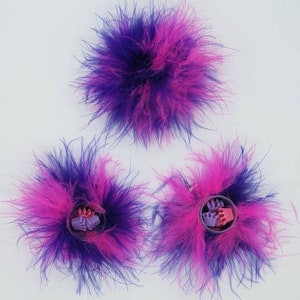 May include: Three pink and purple feather hair clips with a small plastic flower design in the centre.