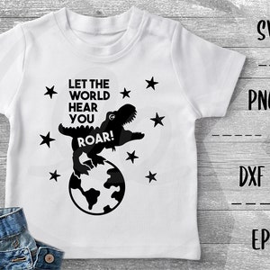 Pode incluir: Uma camiseta branca com um gráfico de dinossauro preto e o texto "Let the world hear you roar!" O dinossauro está em pé em um globo com estrelas ao redor.