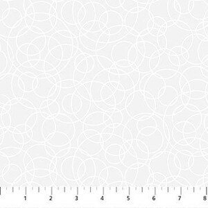 May include: White fabric with a repeating pattern of overlapping, free-form circles. The circles are outlined in white against a light gray background. A ruler is at the bottom, showing measurements in inches.