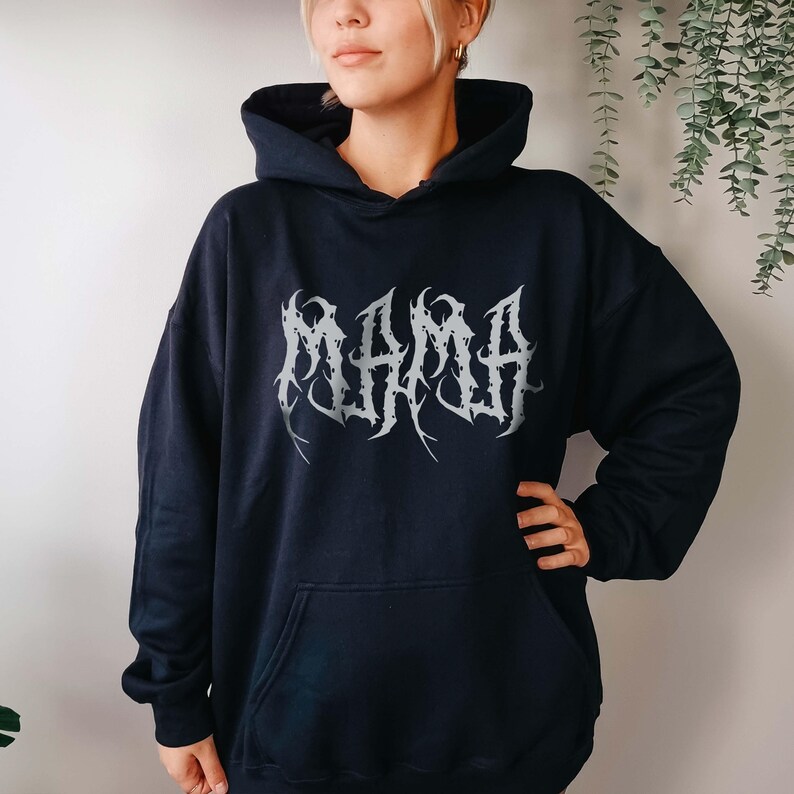Puede incluir: Sudadera con capucha azul marino con bolsillo delantero y capucha. La palabra "MAMA" est&aacute; impresa en plata en el pecho con una fuente g&oacute;tica. La sudadera est&aacute; hecha de un material suave.