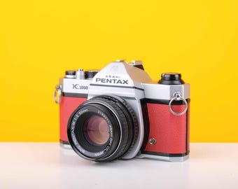 Pentax K1000 35 mm-filmcamera met SMC Pentax M 50 mm f/1.2 prime-lens in rood
