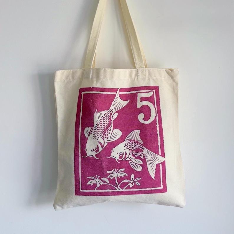 an original canvas color tote bag with dark purple vintage postage stamp style goldfish, japanese koi fish illustration, retro chinese lucky carp fish
