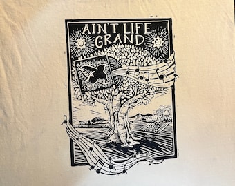 May include: Black and white illustration of a tree with birds and musical notes. The text "Ain't Life Grand" is at the top of the image.