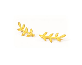May include: A pair of gold leaf ear cuffs. The cuffs are shaped like a branch with small leaves.