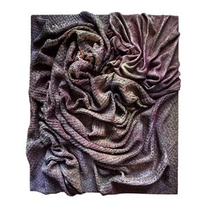 Könnte beinhalten: Texturierte Stoffkunst mit drapierten Falten. Das Kunstwerk zeigt eine Mischung aus Farben, darunter Grautöne, Lila und Goldakzente. Der Stoff ist in einem dynamischen, wirbelnden Muster angeordnet, das ein Gefühl von Tiefe und Bewegung erzeugt. Das Stück ist auf einem quadratischen Träger montiert.