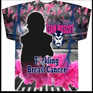 May include: A black and white football jersey with a pink ribbon design. The jersey has the text "Tackling Breast Cancer" and "School Name Team Mascot" with a cartoon devil mascot.