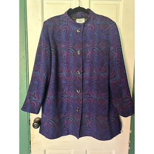 May include: A purple and blue paisley patterned blazer with a mandarin collar and button closure. The label reads "Fiorello".