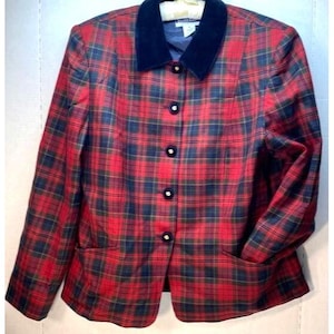 May include: A red, navy, and green plaid blazer with a navy velvet collar. The blazer has six black buttons with white centers and two front pockets. The jacket is a classic style.
