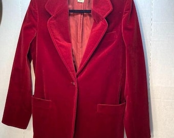 May include: A red velvet blazer with a single button closure and two pockets. The blazer has a label that reads "Carolee XX".