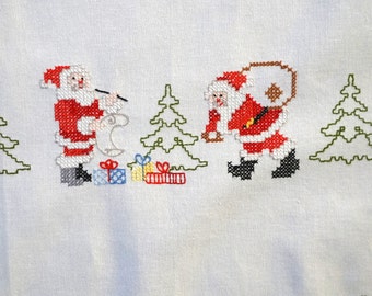 Vintage tablecloth with hand-embroidered Santa Clauses & gifts
