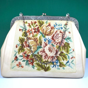 May include: A white vintage purse with a floral embroidered design and a silver chain strap.
