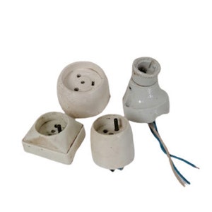 Può includere: Quattro coperture per prese elettriche in ceramica bianca di diverse forme e dimensioni. Le coperture sono tutte in buone condizioni e non presentano danni visibili.
