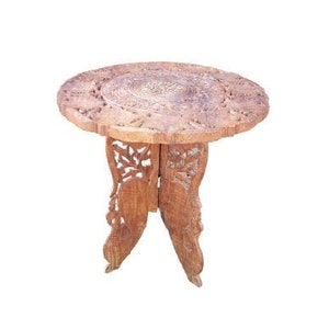 Może przedstawiać: Składany drewniany stolik z misternymi rzeźbami. Blat stołu jest okrągły, a nogi mają kształt stylizowanych liści.