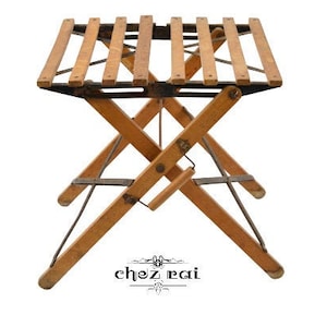 May include: A wooden folding table with a slatted top and black metal supports. The table is in a folded position, with the legs crossed.
