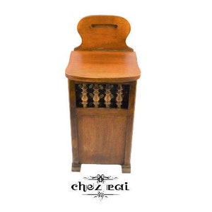 May include: A wooden storage cabinet with a hinged top and a decorative front panel. The cabinet has a dark brown finish and a simple design.