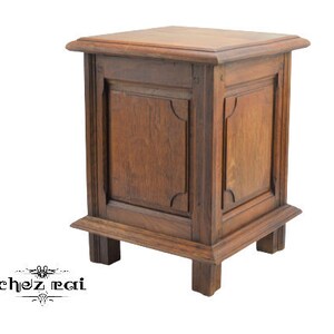 May include: A dark brown wooden end table with a single drawer and four legs. The drawer has a carved design around the edges.