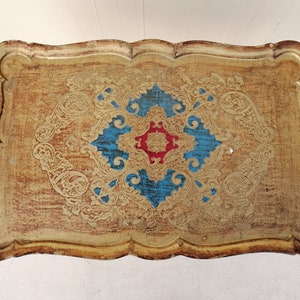 May include: A gold tray with a decorative design featuring blue, red, and gold accents. The tray has a scalloped edge and a distressed finish.