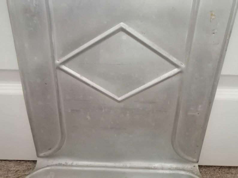 Puede incluir: Un cubo de basura de metal plateado con un dise&ntilde;o en forma de diamante en relieve en la parte delantera.