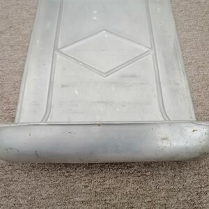 Puede incluir: Una bandeja de metal plateado con un patr&oacute;n de diamante en relieve en la superficie. La bandeja tiene un borde elevado alrededor del borde y un borde curvo en un lado.