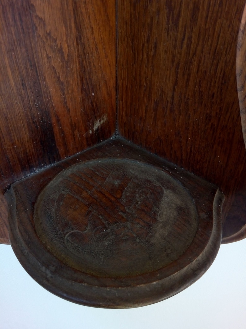 May include: A wooden corner shelf with a carved design on the front. The shelf is made of dark wood and has a rustic look.