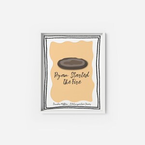 Puede incluir: Una impresión enmarcada en blanco con una forma ovalada marrón y el texto "Ryan Started the Fire" en fuente cursiva negra. El texto "Dunder Mifflin: A Retrospective Series" también está incluido en fuente negra.