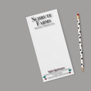May include: A white notepad with the text "Schrute Farms Scranton | Pennsylvania" and a pencil with black polka dots. The notepad also has text at the bottom, including "First in Agrotourism!"