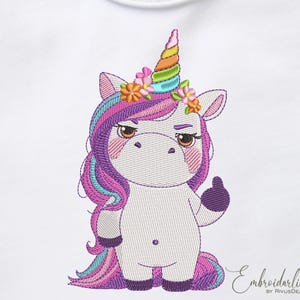 Op de afbeelding: Witte romper met een geborduurd eenhoornontwerp. De eenhoorn heeft een regenbooghoorn, paarse en blauwe manen en geeft een duim omhoog. Het heeft een chagrijnige uitdrukking en is versierd met bloemen. De tekst "Embroiderling by RivusDea" staat rechtsonder.