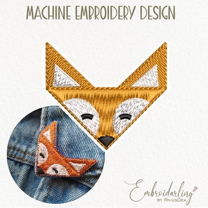 May include: Machine embroidery design of a fox with orange fur, white eyes, and a black nose. The fox is shown on a denim background.