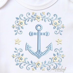May include: Embroidered baby onesie with a nautical theme. Features a light blue anchor in the center, surrounded by a floral wreath with yellow flowers and blue leaves. Two yellow stars are on either side of the anchor.