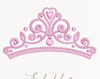 May include: Pink embroidered crown with a heart at the top. The crown has a delicate, ornate design.