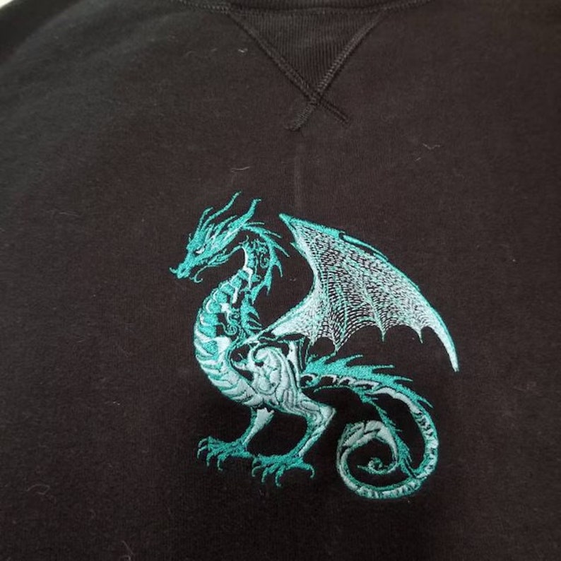 May include: Black sweatshirt with a teal embroidered dragon design.