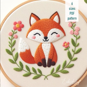 May include: Embroidered pattern of a cute fox with a bushy tail, sitting in a wreath of green leaves and pink flowers. The pattern is available in 6 sizes and is a PDF download. The text "Embroidering by NVUS.DEA" is in the bottom right corner.