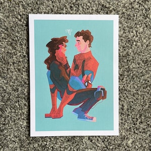 May include: A print featuring a couple in a tender embrace, with the man in a Spider-Man suit. The artwork has a light blue background and a small heart above the couple's heads. The man is wearing a red and blue Spider-Man suit.