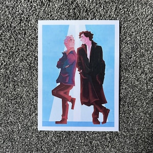 May include: Two men standing side-by-side, one with a light blue jacket and the other with a dark red jacket. They are both looking at each other.