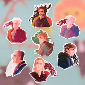 以下が含まれることがあります： キャラクターの様式化された肖像画が描かれた、7つのダイカットステッカーのコレクション。各ステッカーには白い縁取りがあり、ドラゴンまたは他のエンブレムが付いたユニークなキャラクターイラストが描かれています。カラーパレットには、赤、青、茶色が含まれています。