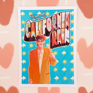 May include: A print featuring a man in an orange suit holding an umbrella, with the words "CALIFORNIA RAIN" in a retro font. The text "The rain won't stop me now!" is above the word "CALIFORNIA". The background is blue with sun and cloud graphics.