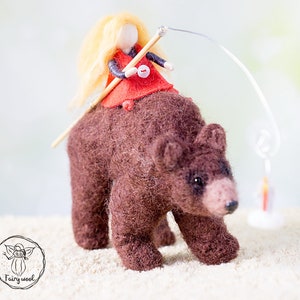 May include: A brown felt bear with a blonde felt doll riding on its back. The doll is holding a stick and a string with a small felt lantern at the end.