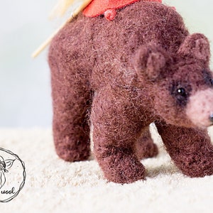 Felt sculpture of wild brown bear and tiny girl in red cloak. The figurine of huntress with lamp. image 7
