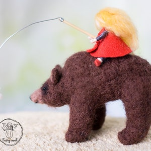 Felt sculpture of wild brown bear and tiny girl in red cloak. The figurine of huntress with lamp. image 2