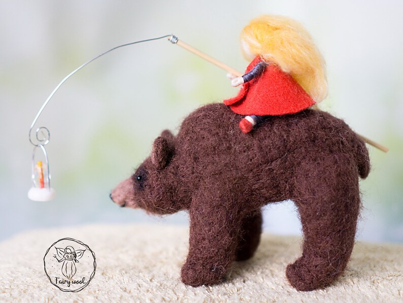 Felt sculpture of wild brown bear and tiny girl in red cloak. The figurine of huntress with lamp. image 2