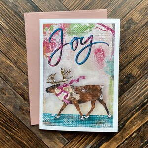 Carte de voeux de joie de renne - carte de correspondance d'hiver de vacances - carte d'animal d'artiste d'aquarelle des bois - art festif coloré de collage rose fantaisiste