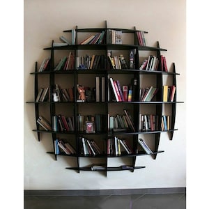 May include: A black circular bookshelf with multiple shelves filled with books. The bookshelf is mounted on a white wall.