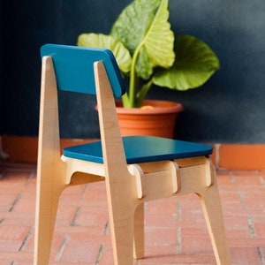 Può includere: Una sedia in legno con seduta e schienale blu turchese. La sedia ha un design semplice e moderno ed è realizzata in legno naturale.